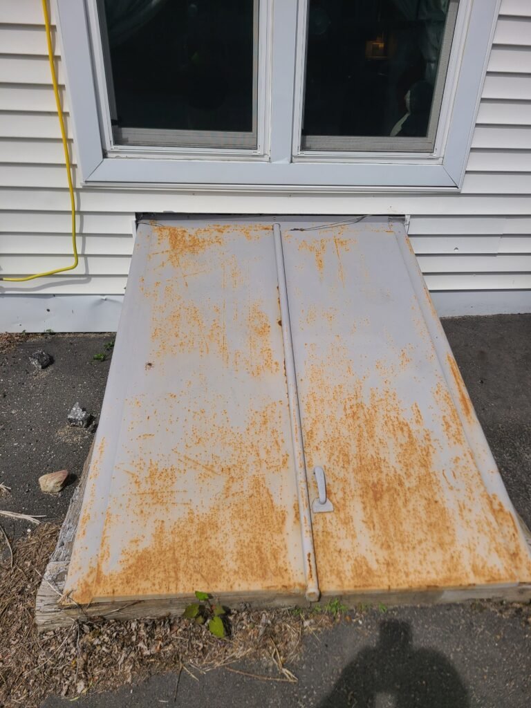 Metal bulkhead door before: faded paint and surface rust