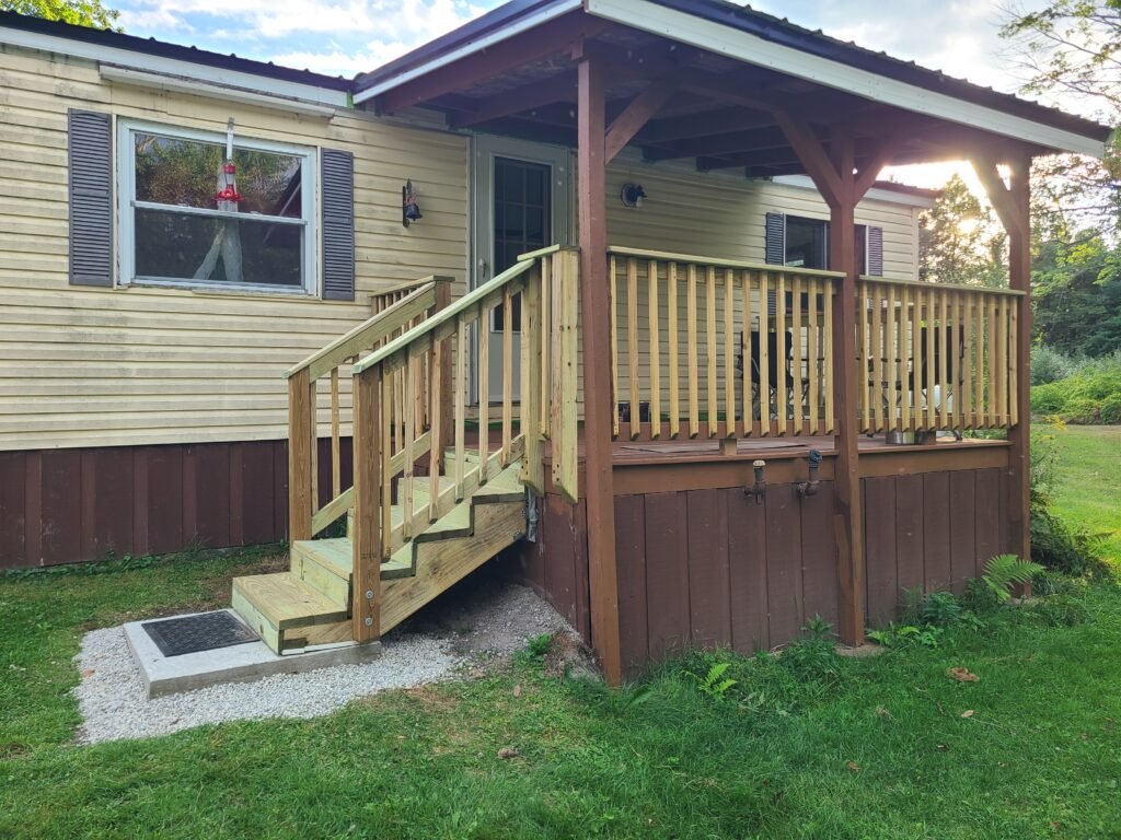Rebuilt deck with new pressure-treated stairs, railings, and concrete landing