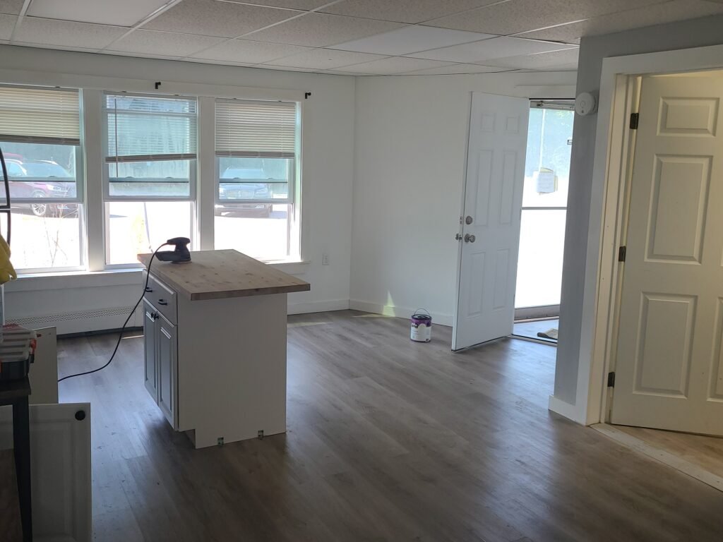 Finished interior renovation: open living area with new flooring, trim, and a kitchen island
